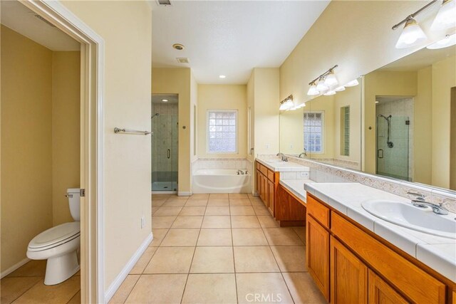 full bathroom featuring a garden tub, a shower stall, a sink, and tile patterned floors