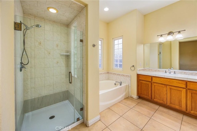 bathroom with a garden tub, tile patterned flooring, vanity, a shower stall, and recessed lighting