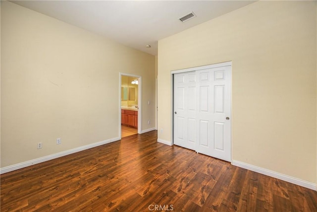 unfurnished bedroom featuring visible vents, dark wood finished floors, and baseboards