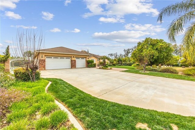 view of front facade with an attached garage, brick siding, fence, driveway, and a front lawn