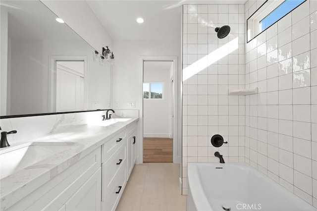 full bath featuring healthy amount of natural light, double vanity, bathtub / shower combination, recessed lighting, and tile patterned flooring