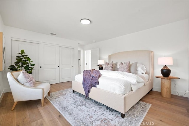 bedroom featuring light wood finished floors, a closet, and baseboards