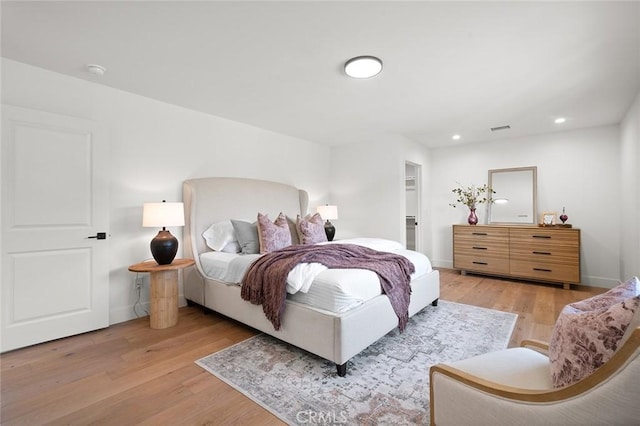 bedroom with light wood finished floors, recessed lighting, and baseboards