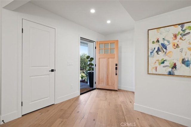 foyer with baseboards, light wood finished floors, and recessed lighting
