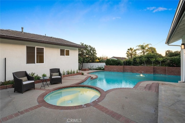 view of pool with a patio and a pool with connected hot tub