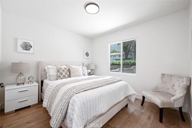 bedroom featuring light wood-style flooring and baseboards