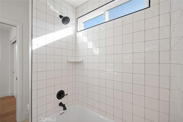 bathroom featuring  shower combination and wood finished floors