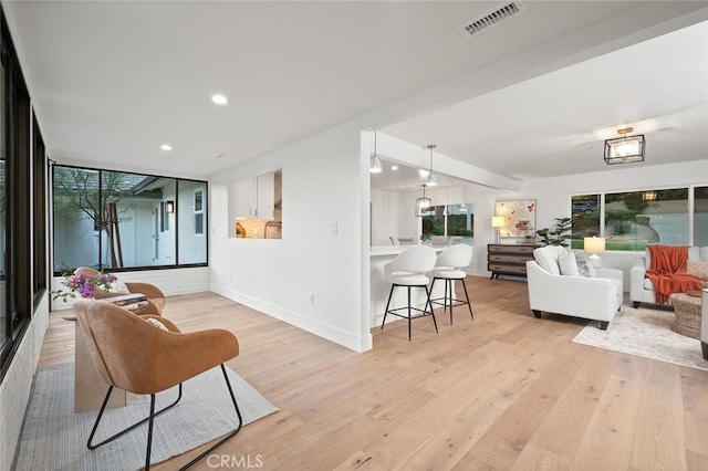 living area featuring recessed lighting, light wood-type flooring, and baseboards