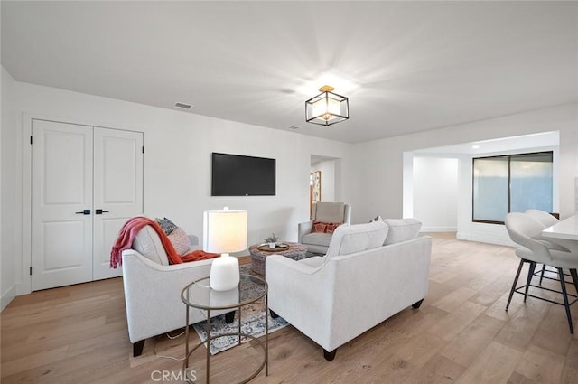 living room with light wood-type flooring and baseboards