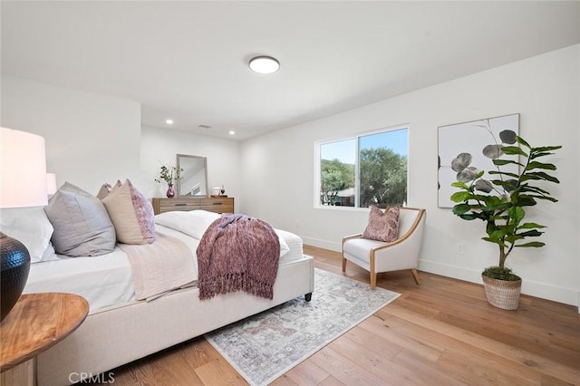 bedroom featuring baseboards, light wood-style flooring, and recessed lighting