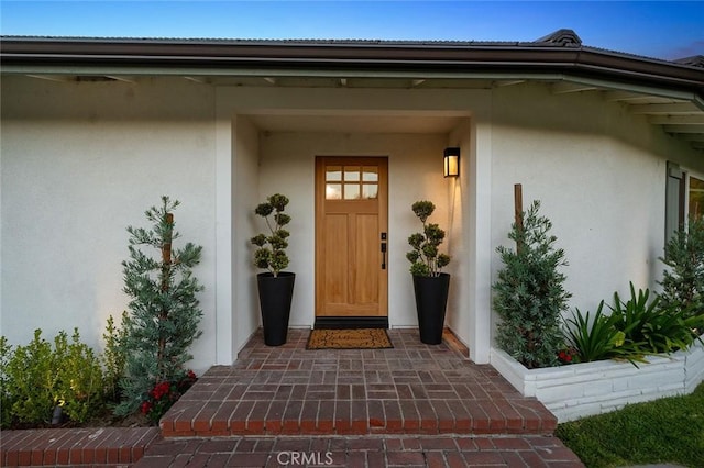 doorway to property featuring stucco siding