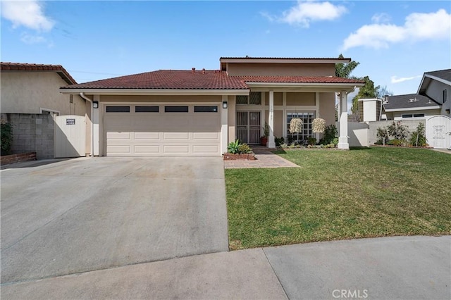 view of front of house with a front yard, a gate, an attached garage, and stucco siding