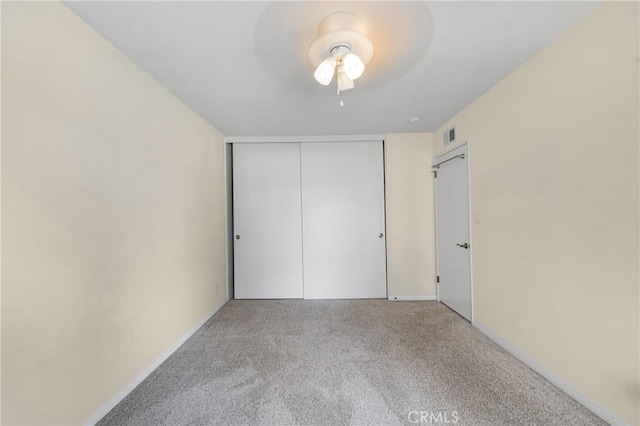 unfurnished bedroom with carpet, a closet, visible vents, a ceiling fan, and baseboards