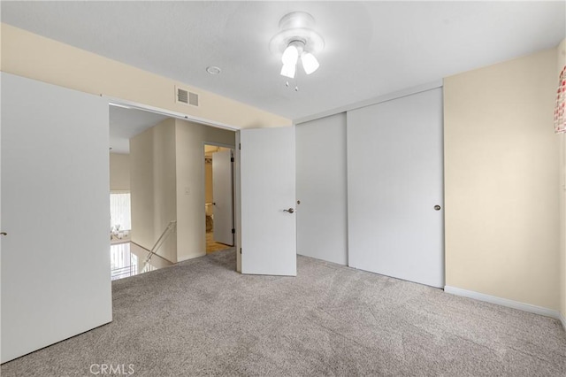 unfurnished bedroom with a closet, visible vents, and carpet flooring