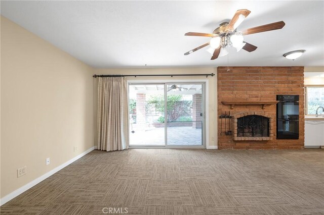 unfurnished living room with carpet floors, plenty of natural light, and a brick fireplace