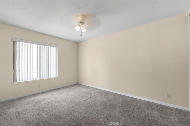 spare room featuring carpet, baseboards, and ceiling fan