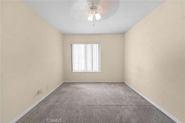 carpeted empty room featuring ceiling fan and baseboards