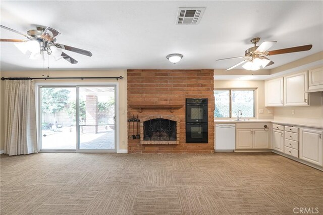 kitchen featuring light colored carpet, visible vents, dishwasher, and dobule oven black