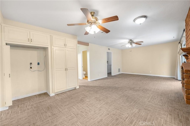 unfurnished living room featuring light carpet, a ceiling fan, and baseboards