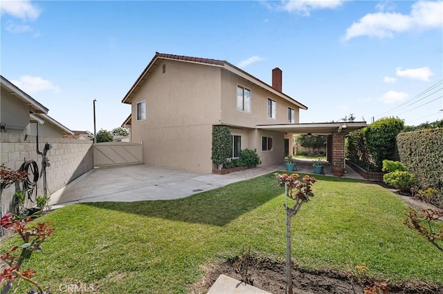 rear view of property featuring a patio area, fence, a lawn, and stucco siding