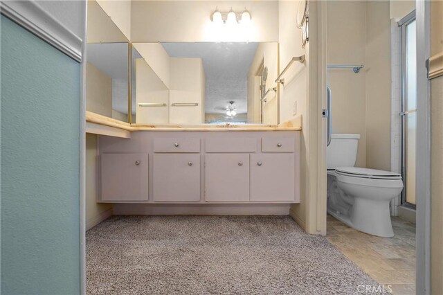 bathroom with toilet, an enclosed shower, and vanity