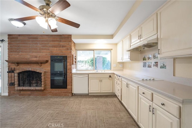 kitchen featuring under cabinet range hood, white appliances, a fireplace, a ceiling fan, and light countertops