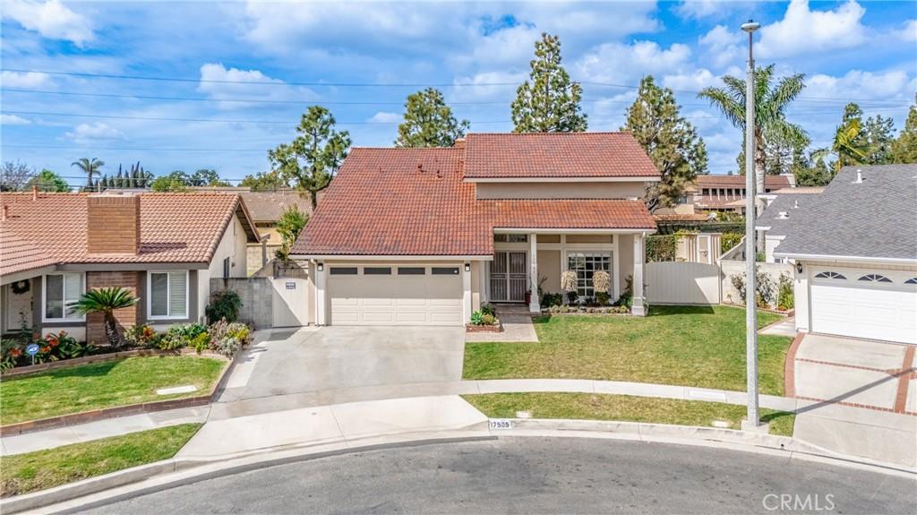 17505 Kensington Cir, Cerritos, CA 90703 - view of front of property featuring a tile roof, concrete driveway, a gate, fence, and a front lawn