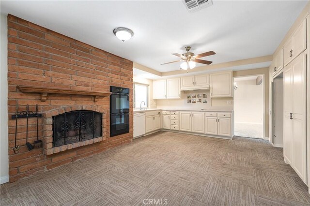 kitchen featuring light colored carpet, dobule oven black, visible vents, white dishwasher, and a sink