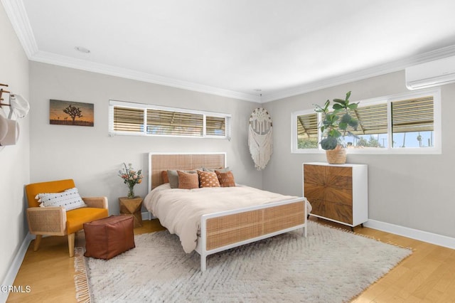 bedroom with crown molding, a wall unit AC, wood finished floors, and baseboards