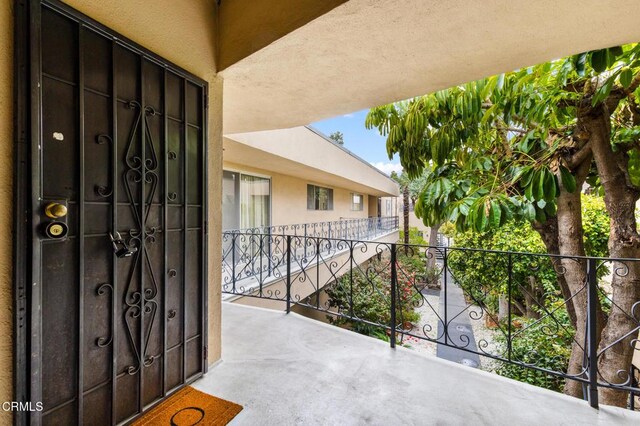 doorway to property with a balcony and stucco siding