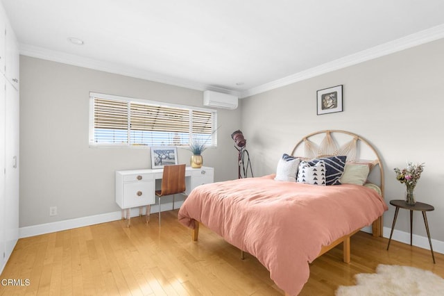 bedroom with light wood finished floors, baseboards, ornamental molding, and a wall mounted air conditioner