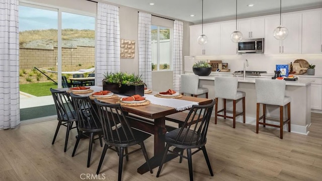 dining room with recessed lighting, light wood-type flooring, and a healthy amount of sunlight