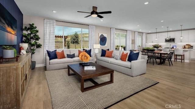 living room with light wood finished floors, a wealth of natural light, and recessed lighting