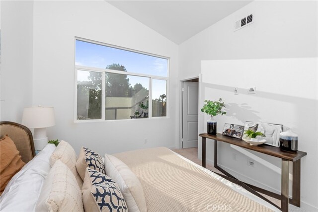 bedroom featuring lofted ceiling and visible vents