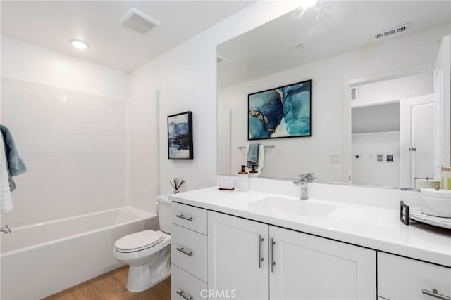 full bath with toilet, visible vents, wood finished floors, and vanity