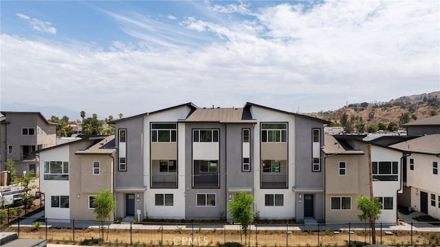 view of building exterior featuring a fenced front yard and a residential view