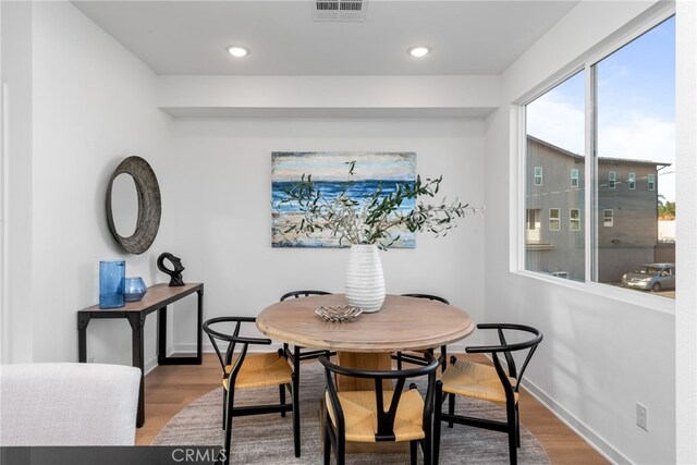 dining room featuring baseboards, visible vents, wood finished floors, and recessed lighting