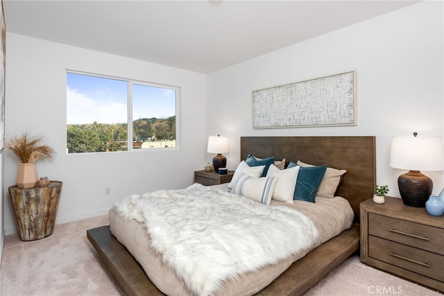 bedroom with light carpet and baseboards