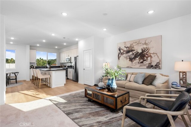 living area featuring light wood-type flooring and recessed lighting