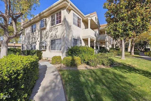 view of side of home with a yard and stucco siding