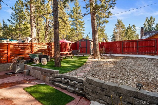 view of yard featuring an outbuilding, a shed, a patio area, and a fenced backyard