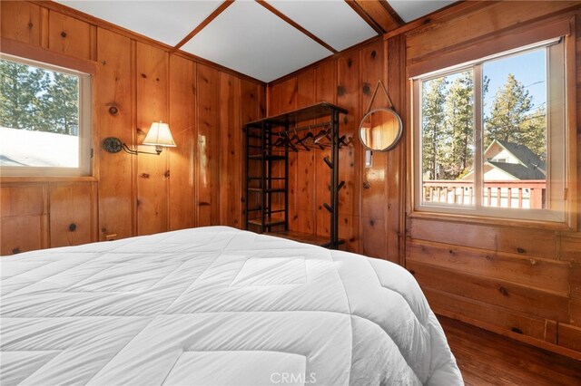 bedroom featuring wood walls and wood finished floors