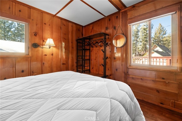 bedroom with wood finished floors and wood walls