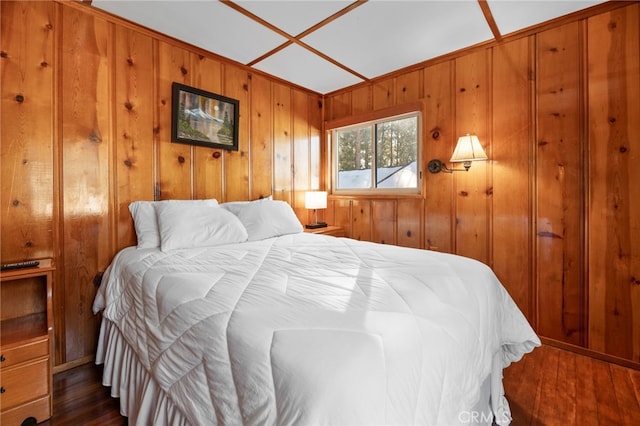 bedroom with dark wood-style floors and wood walls