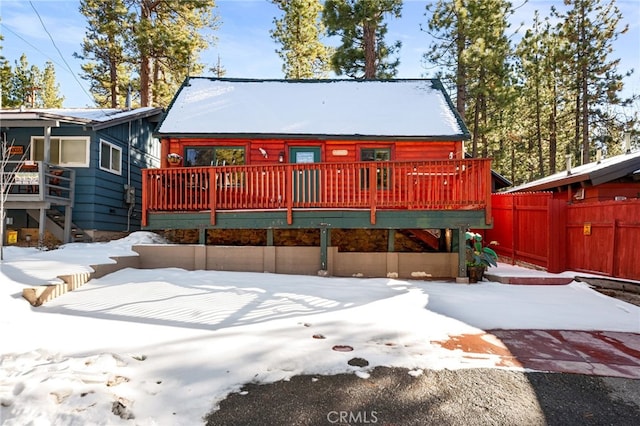 view of front of house with a deck and fence