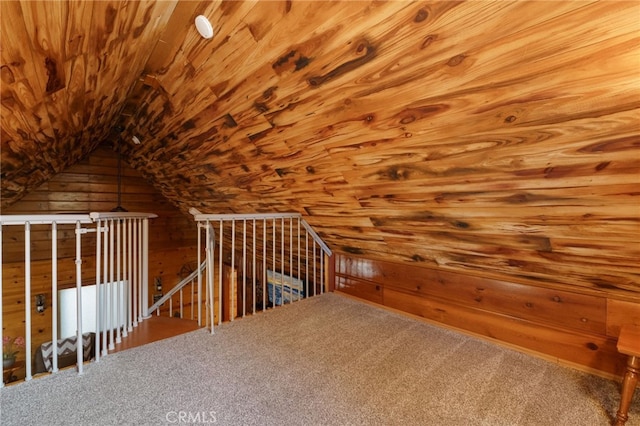 additional living space with carpet, vaulted ceiling, wood ceiling, and wood walls