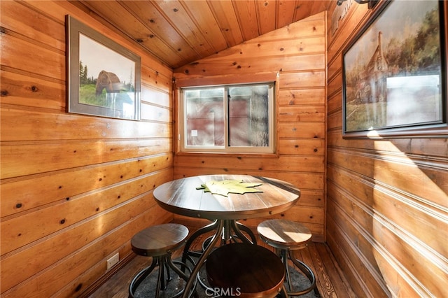 dining area featuring lofted ceiling, wood ceiling, and wooden walls