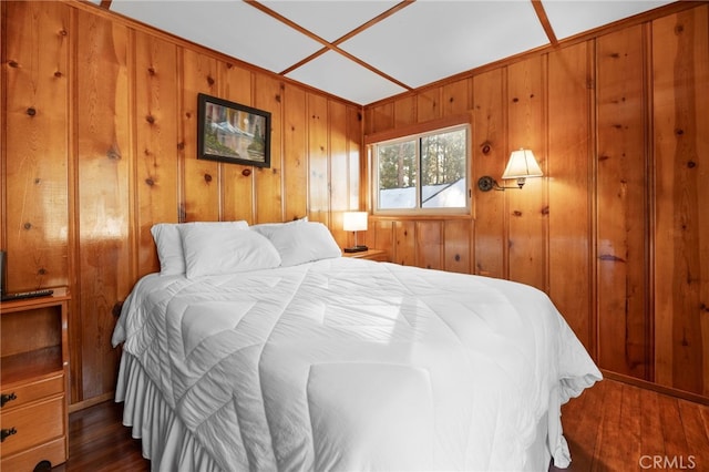 bedroom with dark wood-type flooring and wooden walls