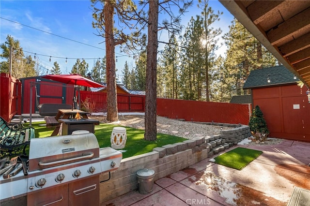 view of patio with an outdoor fire pit and a fenced backyard