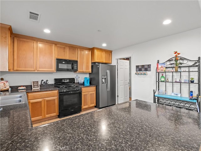 kitchen featuring recessed lighting, visible vents, a sink, and black appliances